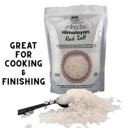 White Himalayan salt coarse crystals being ground in salt mill over food